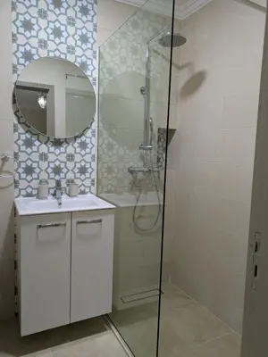 a bathroom with a shower and a sink and a mirror at Majorelle green Spa Suite in Marrakech