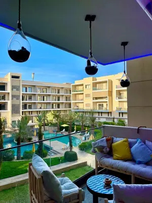 a balcony with a couch and a view of a building at Luxury Pool View Marrakech in Marrakech
