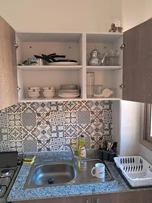 a kitchen with a sink and a tiled wall at comfortable stay in Marrakesh in Marrakech