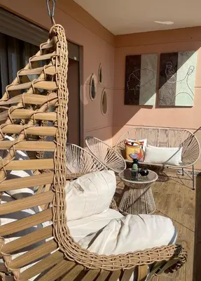 a hanging rattan chair in a living room at Appartement luxe avec piscine in Marrakech