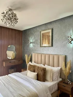 a bedroom with a large bed and a chandelier at Appartement luxe avec piscine in Marrakech