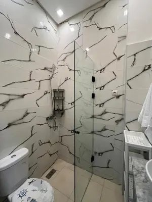 a bathroom with a toilet and a glass shower at Garden Apartment 5 min from Gueliz in Marrakech