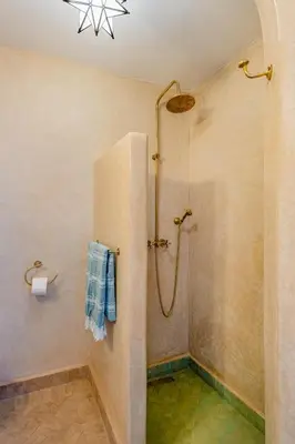a bathroom with a shower with a blue towel at Riad JewelBox Exclusive Stay In the Medina in Marrakech