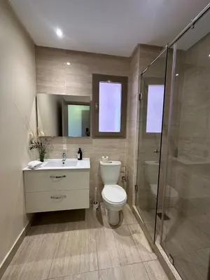 a bathroom with a toilet and a sink and a shower at Prestigia Jade Beautiful Apartment Marrakesh in Marrakech