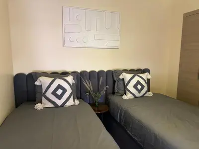 two beds sitting next to each other in a room at Prestigia Jade Beautiful Apartment Marrakesh in Marrakech