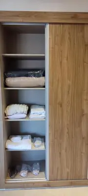 a wooden cabinet with towels and other items in it at Light filled Urban Retreat in Marrakech