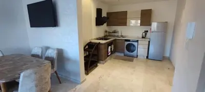 a kitchen with a refrigerator and a table in it at Light filled Urban Retreat in Marrakech