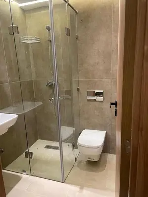 a bathroom with a shower with a toilet and a sink at Light filled Urban Retreat in Marrakech