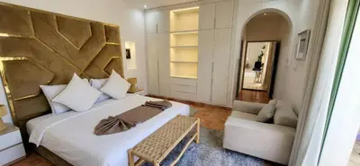 a bedroom with a bed and a chair and a mirror at Villa Riad Dar Sukar in Marrakech