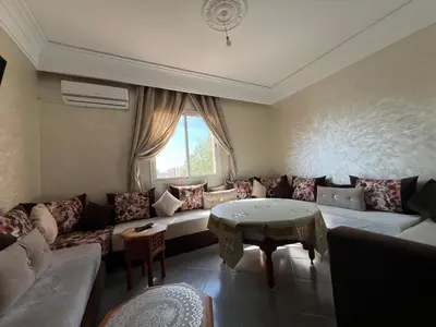 a living room with a couch and a table at Cozy & Modern Apartment Minutes from Menara Airport in Marrakech