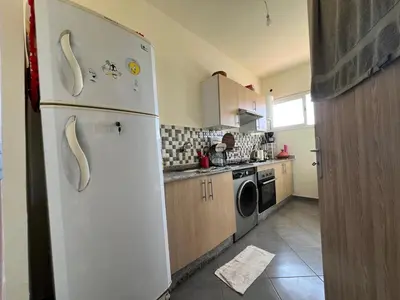 a kitchen with a white refrigerator and a dishwasher at Cozy & Modern Apartment Minutes from Menara Airport in Marrakech