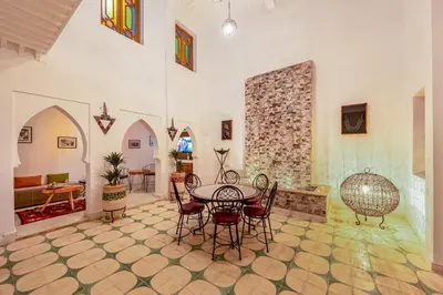 a living room with a table and chairs at Riad Cherifa Breakfast and Jacuzzi Terrace in Marrakech
