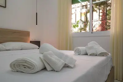 a white bedroom with two beds with towels on them at Marrakech Gueliz Apartement in Marrakech