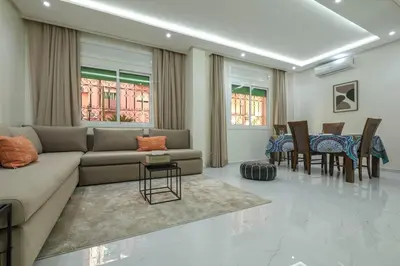 a living room with a couch and a table and chairs at Marrakech Gueliz Apartement in Marrakech