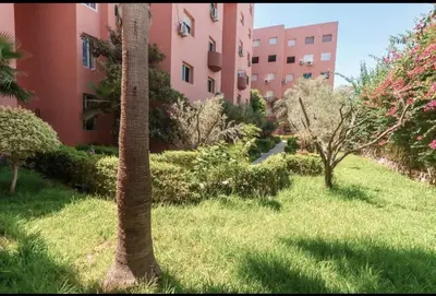 a palm tree in front of a building at Marrakech Gueliz Apartement in Marrakech