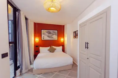 a bedroom with a white bed and a red wall at Maison beldi loft in Marrakech