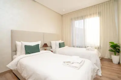 two white beds in a room with a window at Gueliz - Pool & Jacuzzi - Luxury Residence in Marrakech