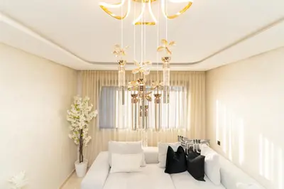 a living room with a white couch and a chandelier at Gueliz - Pool & Jacuzzi - Luxury Residence in Marrakech