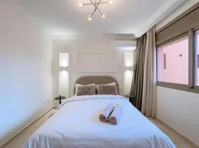 a bedroom with a bed with two slippers on it at Modern & Luxurious Apartment, Terrace with panoramic view of Gueliz in Marrakech