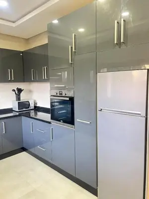 a kitchen with a stainless steel refrigerator and cabinets at Villa luxe, tranquillité aux portes de Marrakech in Marrakech