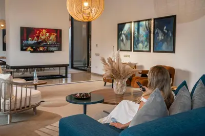a woman sitting on a couch in a living room at Resort Batoul nor marrakech in Marrakech