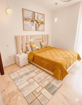a bedroom with a bed with a yellow bedspread at Studio haut standing in Marrakech