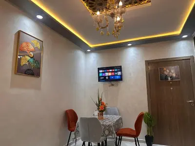 a dining room with a table and chairs and a chandelier at Aljawhara 2BD in Marrakech