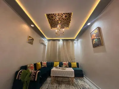 a living room with a couch and a chandelier at Aljawhara 2BD in Marrakech
