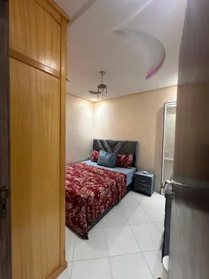 a bedroom with a bed with a red blanket at Aljawhara 2BD in Marrakech