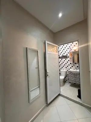 a bathroom with a toilet and two mirrors on the wall at Aljawhara 2BD in Marrakech