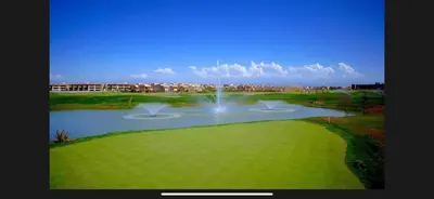 a fountain in the middle of a golf course at 2 chambre Prestigia Jade golf city in Marrakech