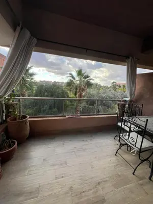 a balcony with a view of a palm tree at 2 chambre Prestigia Jade golf city in Marrakech