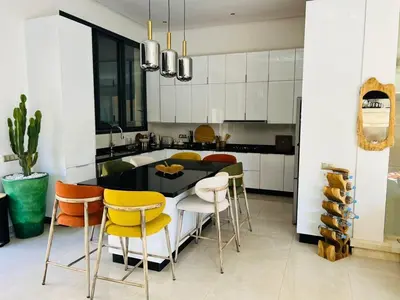 a kitchen with a black table and yellow chairs at Villa Familiale - Idéale pour Groupe jusqu'à 10 Personnes in Marrakech