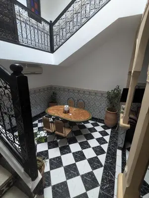 a room with a table and a checkered floor at Riad absar in Marrakech