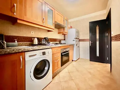 a kitchen with a washing machine and a refrigerator at Elegant Cocoon 2 Bedrooms, Pool & Rooftop in Marrakech