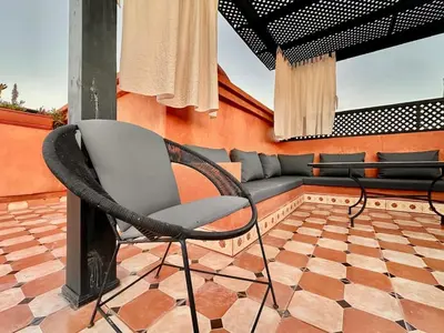 a chair and a couch on a patio at Elegant Cocoon 2 Bedrooms, Pool & Rooftop in Marrakech