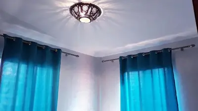 a bathroom with a chandelier and blue curtains at Beautiful apartment 5' from Macdonald, 10' from Downtown in Marrakech