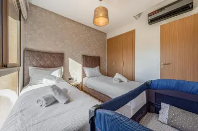 a hotel room with two beds and a couch at Prestigia Opale - Superb condo with Golf & Pool views in Marrakech