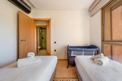 a bedroom with two beds and a door with a mirror at Prestigia Opale - Superb condo with Golf & Pool views in Marrakech