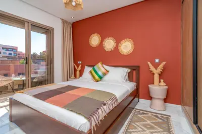 a bedroom with a large bed and a balcony at Appartement Romantique et Moderne a Gueliz in Marrakech