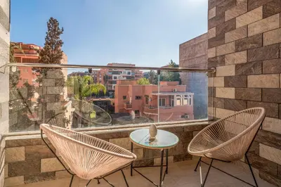 a balcony with two chairs and a table at Appartement Romantique et Moderne a Gueliz in Marrakech