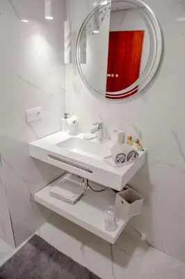 a white bathroom with a sink and a mirror at Luxurious apartment in Marrakech