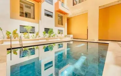 an indoor swimming pool in a house with plants at Premium studio - Hivernage Marrakech in Marrakech