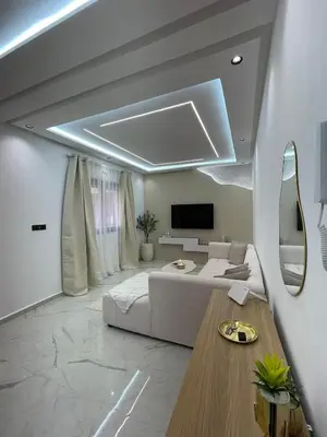a living room with a couch and a tv at Premium studio - Hivernage Marrakech in Marrakech