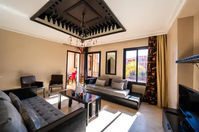 a living room with a couch and a tv at River Palm élégant appartement 2 ch vue piscine in Marrakech