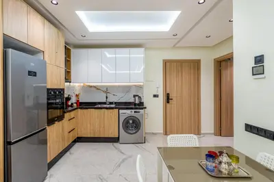 a kitchen with a refrigerator and a dishwasher at Stylish Flat, Aube hivernage Fibre-Pool & Parking in Oulad Akkou
