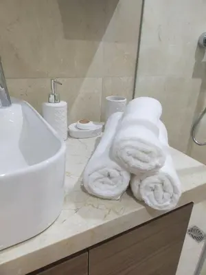 a bathroom with a sink and towels on a counter at High Standing Duplex & Pool 10 min Center in Marrakech