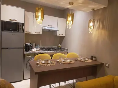a kitchen with a wooden table with yellow chairs at High Standing Duplex & Pool 10 min Center in Marrakech