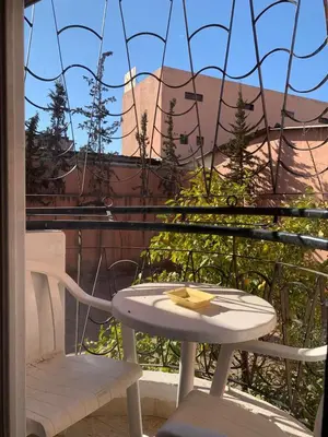 a table and two chairs on a balcony with a view at Comfort Appartment Centre Marrakech in Marrakech