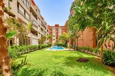 an apartment yard with a swimming pool in a building at Appartement moderne 5 min au centre ville in Marrakech